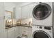 Well-organized laundry room with white cabinets, dark countertop and a stacked washer and dryer at 523 Coaxum Rd, Mount Pleasant, SC 29464