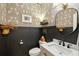 Stylish powder room featuring floral wallpaper, dark wainscoting, and elegant fixtures at 523 Coaxum Rd, Mount Pleasant, SC 29464