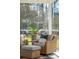 Cozy screened porch sitting area with wicker chairs and a view of the wooded backyard at 523 Coaxum Rd, Mount Pleasant, SC 29464
