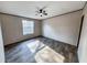 A bedroom has hardwood floors, neutral colored walls, ceiling fan, and a large window at 532 Finlay Ln, Cottageville, SC 29435