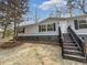Exterior of home with gray siding, black shutters, and a wooden staircase leading to the front door at 532 Finlay Ln, Cottageville, SC 29435