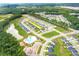 Stunning aerial view of a Primary-planned community, showcasing lush greenery, lake, pool, and well-maintained homes at 577 Red Monarch Way, Moncks Corner, SC 29461