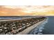 Majestic aerial view of beachfront properties nestled between ocean and marsh with vibrant skies at 702 E Erie Ave, Folly Beach, SC 29439