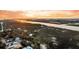 Scenic aerial view of waterfront houses bordered by trees and a serene river at sunset at 702 E Erie Ave, Folly Beach, SC 29439