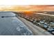 Beautiful sunset aerial of a coastal town, featuring an adjacent fishing pier on the beach at 702 E Erie Ave, Folly Beach, SC 29439