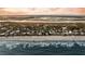 Breathtaking overhead view of beach homes, sandy shoreline, and the gentle ocean waves at 702 E Erie Ave, Folly Beach, SC 29439
