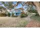 The backyard features a spacious lawn, mature trees, and a wooden deck, perfect for outdoor living at 702 E Erie Ave, Folly Beach, SC 29439
