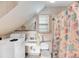 Compact bathroom with a washing machine, sink, toilet, and a shower with a colorful curtain at 702 E Erie Ave, Folly Beach, SC 29439