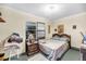 Simple bedroom featuring a wooden bed frame, nightstand, and a window with blinds at 702 E Erie Ave, Folly Beach, SC 29439