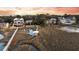 Aerial view showcases waterfront homes with marsh views and a wooden dock leading to a peaceful cove at 702 E Erie Ave, Folly Beach, SC 29439
