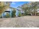 Two-story home with a well-maintained lawn and mature trees with a paved pathway at 702 E Erie Ave, Folly Beach, SC 29439