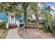 Inviting covered front porch with white railings and a bench, surrounded by lush greenery at 702 E Erie Ave, Folly Beach, SC 29439