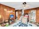 Spacious living room featuring wood paneling, a ceiling fan, and access to the bathroom and stairs at 702 E Erie Ave, Folly Beach, SC 29439