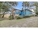 Backyard view of a charming blue two-story home with a wooden deck overlooking the beautiful marsh at 702 E Erie Ave, Folly Beach, SC 29439