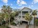 Aerial view of a well-maintained home with a screened porch featuring beautiful palm trees surrounding the property at 707 Ocean Blvd, Isle of Palms, SC 29451