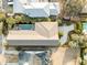 Aerial view of house with pool, well-manicured landscaping, driveway, and roof in a neighborhood with mature trees at 707 Ocean Blvd, Isle of Palms, SC 29451