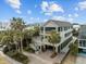 Aerial view of a beautiful home with multi-level deck, palm trees, and well-manicured lawn at 707 Ocean Blvd, Isle of Palms, SC 29451