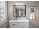 A well-lit bathroom vanity with marble countertop paired with a window and fresh white towels at 707 Ocean Blvd, Isle of Palms, SC 29451
