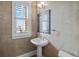 Charming powder room featuring a pedestal sink, decorative mirror, and plantation shutters at 707 Ocean Blvd, Isle of Palms, SC 29451