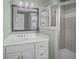This bathroom offers a white vanity and a glass shower with neutral wall tile at 707 Ocean Blvd, Isle of Palms, SC 29451