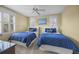 Charming bedroom with two beds featuring a ceiling fan and bright, airy windows at 707 Ocean Blvd, Isle of Palms, SC 29451