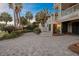Paver driveway leading to a charming home with staircase, beautiful landscaping, and tropical palm trees at 707 Ocean Blvd, Isle of Palms, SC 29451