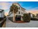 Charming three-story home with green shutters and balconies, complemented by lush landscaping and a paved driveway at 707 Ocean Blvd, Isle of Palms, SC 29451