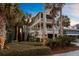 Beautiful home featuring a double-decker screened porch surrounded by lush landscaping including mature palm trees and shrubbery at 707 Ocean Blvd, Isle of Palms, SC 29451