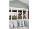 Bright living room with a comfy sofa and view of an outdoor porch and tropical landscaping at 707 Ocean Blvd, Isle of Palms, SC 29451