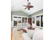 Comfortable living room with ceiling fan and deck access overlooking palm trees and blue beach homes at 707 Ocean Blvd, Isle of Palms, SC 29451
