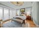 Bright main bedroom features tray ceilings, hardwood floors, and sliding glass doors at 707 Ocean Blvd, Isle of Palms, SC 29451