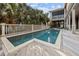Inviting backyard pool with wooden decking, privacy fence and a glimpse of the outdoor seating area on the screened porch at 707 Ocean Blvd, Isle of Palms, SC 29451