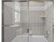 Tiled shower featuring glass door, and showerhead with built in soap-dish at 707 Ocean Blvd, Isle of Palms, SC 29451