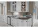 Elegant wet bar with white cabinetry, a sink, and stylish shelving for drinkware and decor at 707 Ocean Blvd, Isle of Palms, SC 29451