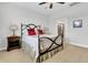 The bedroom has a wrought iron bed frame, tan carpet, and bedside table with doorway to a bathroom at 733 Spring Highlands Dr, Summerville, SC 29486