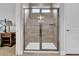 Walk-in shower featuring light brown tiling, a built-in shelf, and a glass door with steel trim at 733 Spring Highlands Dr, Summerville, SC 29486