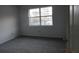 Clean, carpeted bedroom with a window overlooking the outdoors, perfect for relaxation at 7851 Sandida Ct, North Charleston, SC 29418