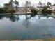 Beautiful pond view with reflections of the sky, trees, and community buildings for relaxing scenery at 7851 Sandida Ct, North Charleston, SC 29418