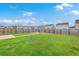 Large backyard with green grass, a small firepit area, and a tall wood fence at 787 Redbud Ln, Summerville, SC 29486