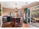 Charming dining area with wood floors, backyard access, and a modern light fixture and barstool seating at 8005 Old Hazelwood Rd, North Charleston, SC 29406