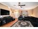 Inviting living room features a ceiling fan, large TV, and comfortable seating area with decorative rug at 8005 Old Hazelwood Rd, North Charleston, SC 29406