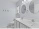 Bathroom featuring double sinks and mirrors and white cabinets at 8147 Shadow Oak Dr, North Charleston, SC 29406