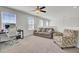 Bright bedroom featuring carpet floors, ceiling fan, sofa, and desk area at 9712 Transplanter Cir, Ladson, SC 29456
