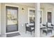 Inviting front porch with seating area, featuring a stylish door and well-placed lighting at 9712 Transplanter Cir, Ladson, SC 29456