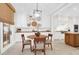 Bright dining area features a round table with seating and decorative lighting fixture adjacent to a modern kitchen at 1 Vendue Range # D, Charleston, SC 29401