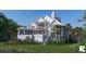 Stunning two-story home with white siding, multiple balconies, and lush landscaping at 1077 Ship Builder St, Charleston, SC 29492