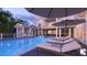 Relaxing poolside with multiple lounge chairs and umbrellas with a partial view of the home at 1077 Ship Builder St, Charleston, SC 29492