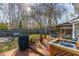 Spacious backyard featuring a wooden deck, patio seating, lush lawn and mature trees providing ample shade at 115 Laurel Ridge Rd, North Charleston, SC 29418