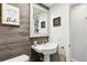Charming powder room features a pedestal sink, wood accent wall, and fun decor at 115 Laurel Ridge Rd, North Charleston, SC 29418