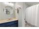 Bright bathroom featuring blue cabinets, a neutral countertop, and a round mirror at 115 Laurel Ridge Rd, North Charleston, SC 29418